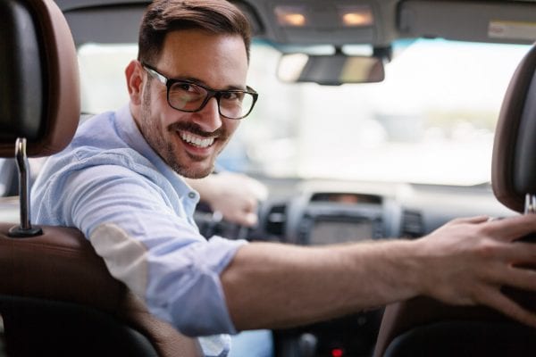 Cheap Car Insurance Rates in Florida - Image of Man Smiling Driving - Kirby Soar Insurance
